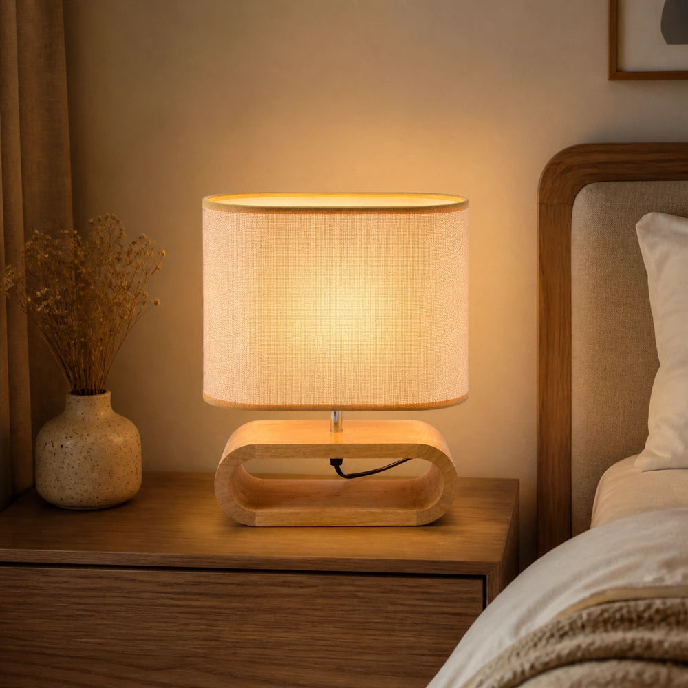 Luminária de mesa com base de madeira nórdica e cúpula de tecido acesa em quarto elegante