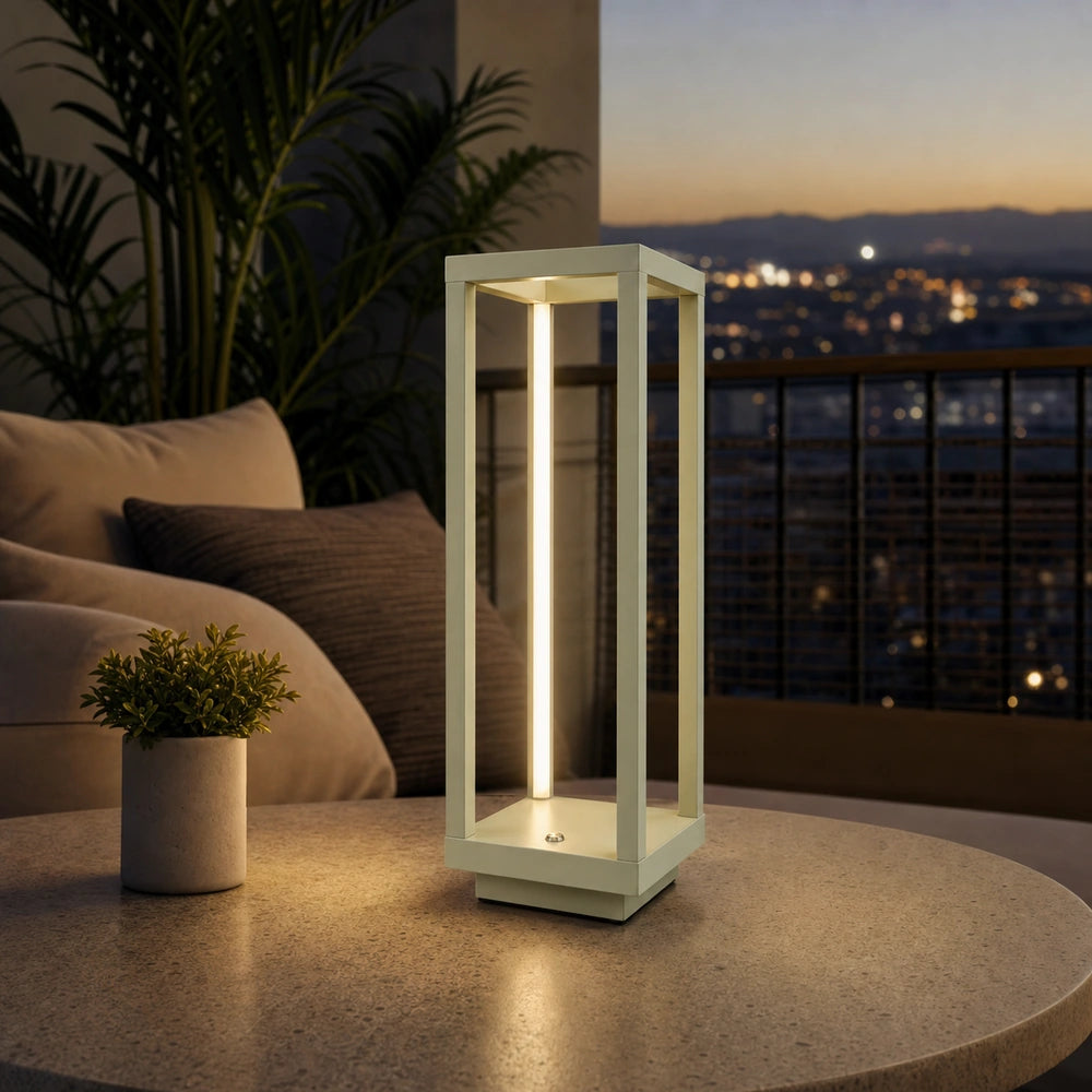 Luminária de mesa LED sem fio em verde sálvia acesa sobre mesa de varanda protegida