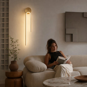 Pessoa relaxando em sala com luminária de parede LED linear dourada