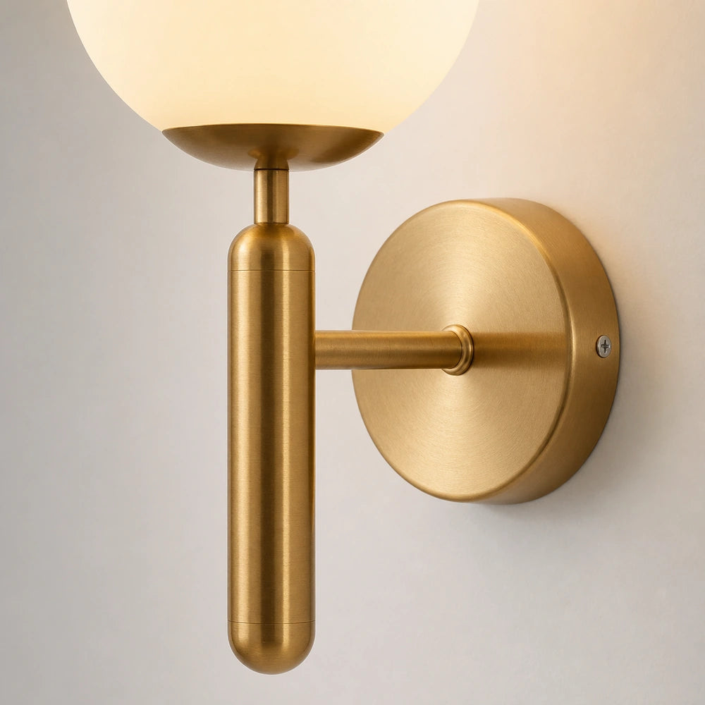 Detalhe do acabamento dourado da arandela de parede com globo branco