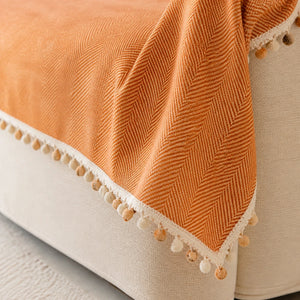 Detalhe da borda e do acabamento da manta para sofá laranja
