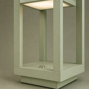 Detalhe da base quadrada e das quatro colunas da luminária de mesa em formato de lanterna