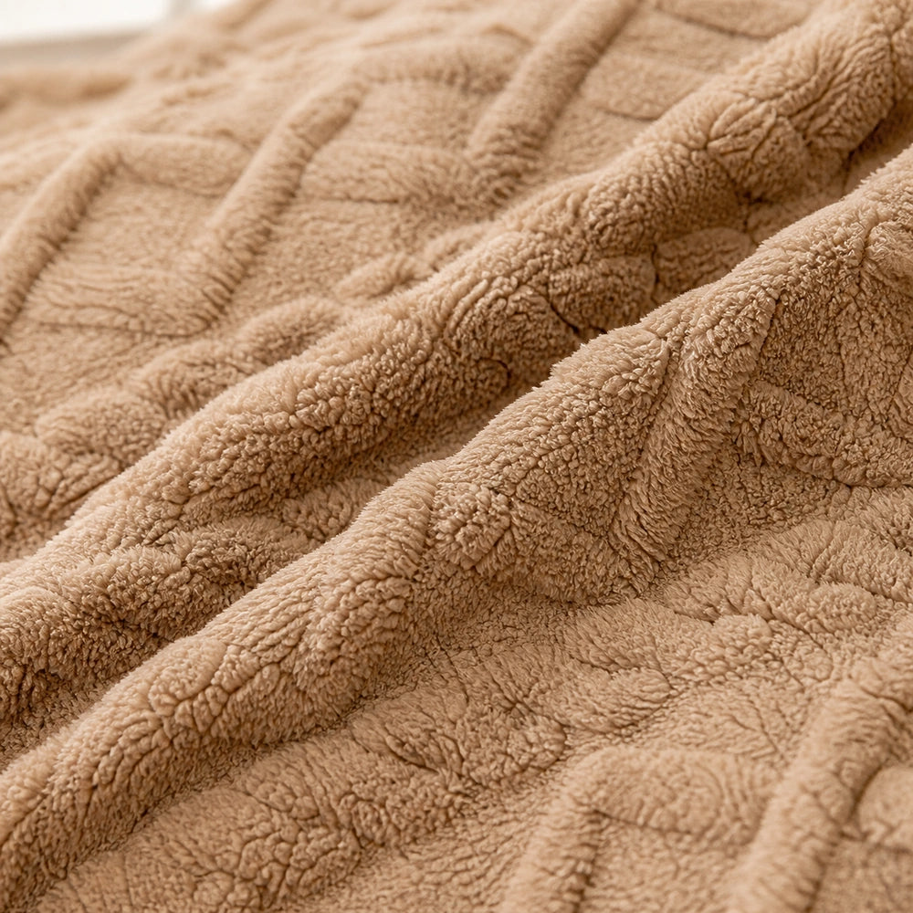 Detalhe do fleece e do padrão jacquard xadrez da manta marrom