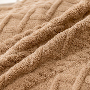 Detalhe do fleece e do padrão jacquard xadrez da manta marrom