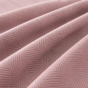 Detalhe da textura real da manta para sofá rosa