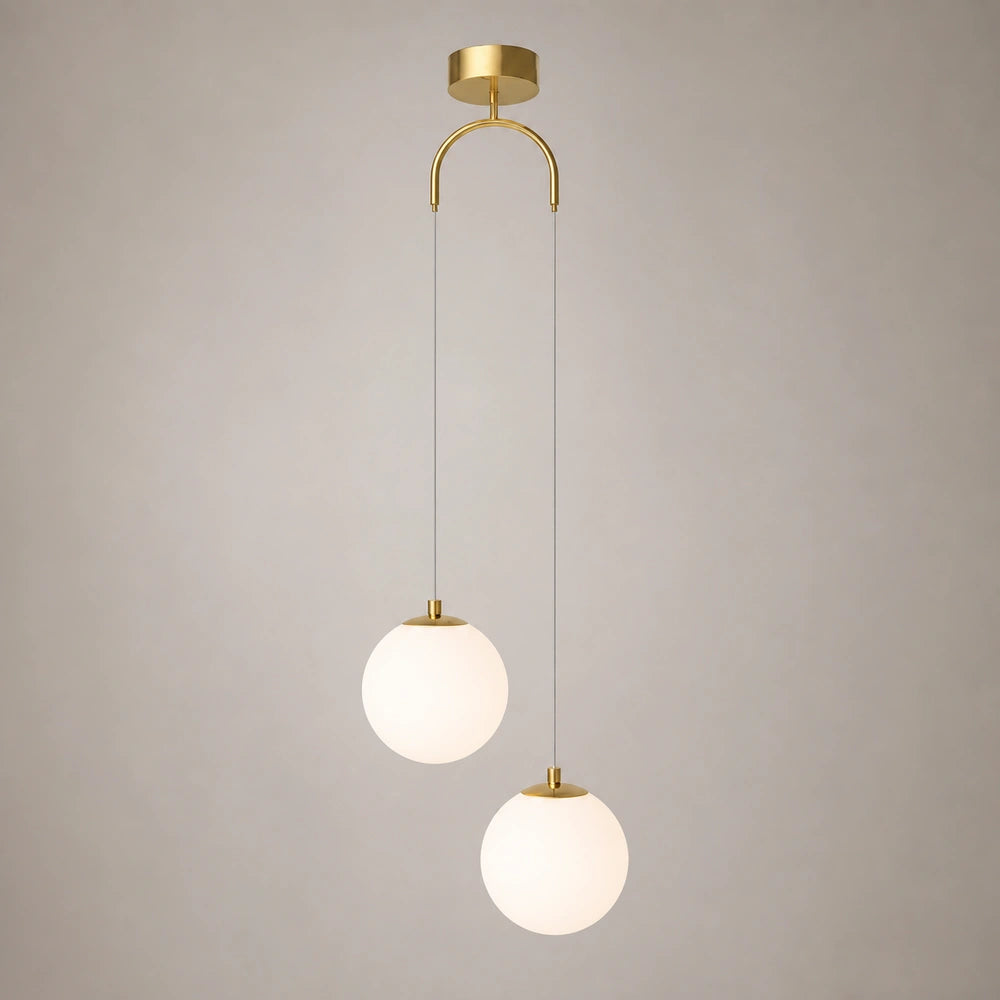 Lustre pendente dourado com 2 luminárias sobre fundo neutro