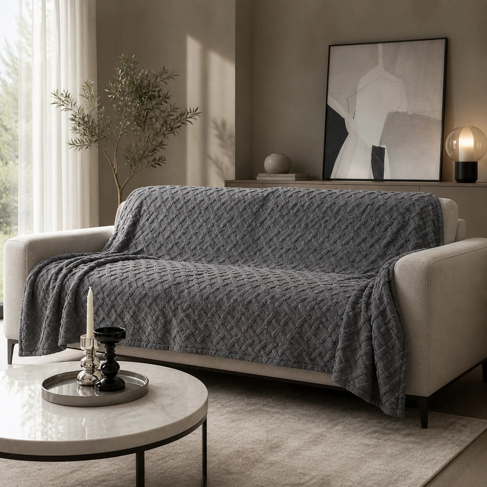 Manta para sofá grande cinza escuro em fleece jacquard sobre sofá em ambiente sofisticado